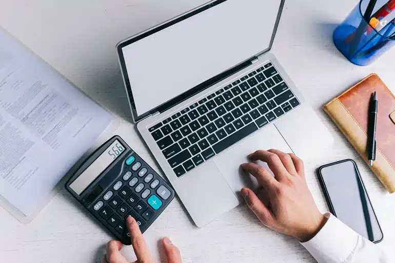 person using calculator to calculate tax income