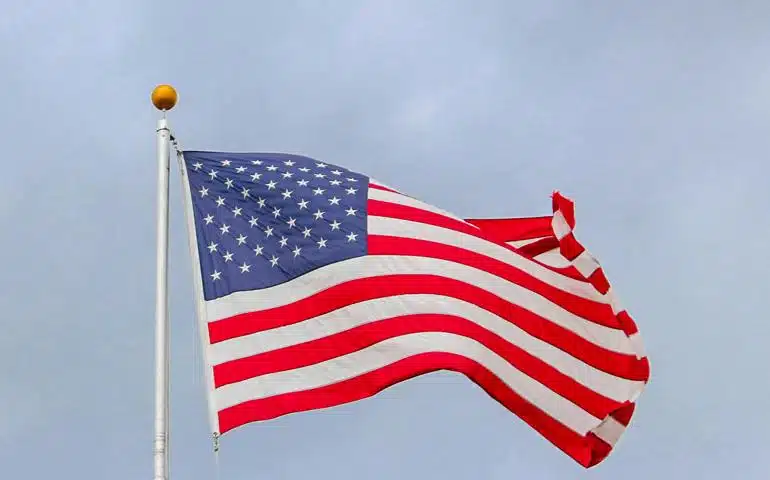 USA Flag Waving On White Metal Pole